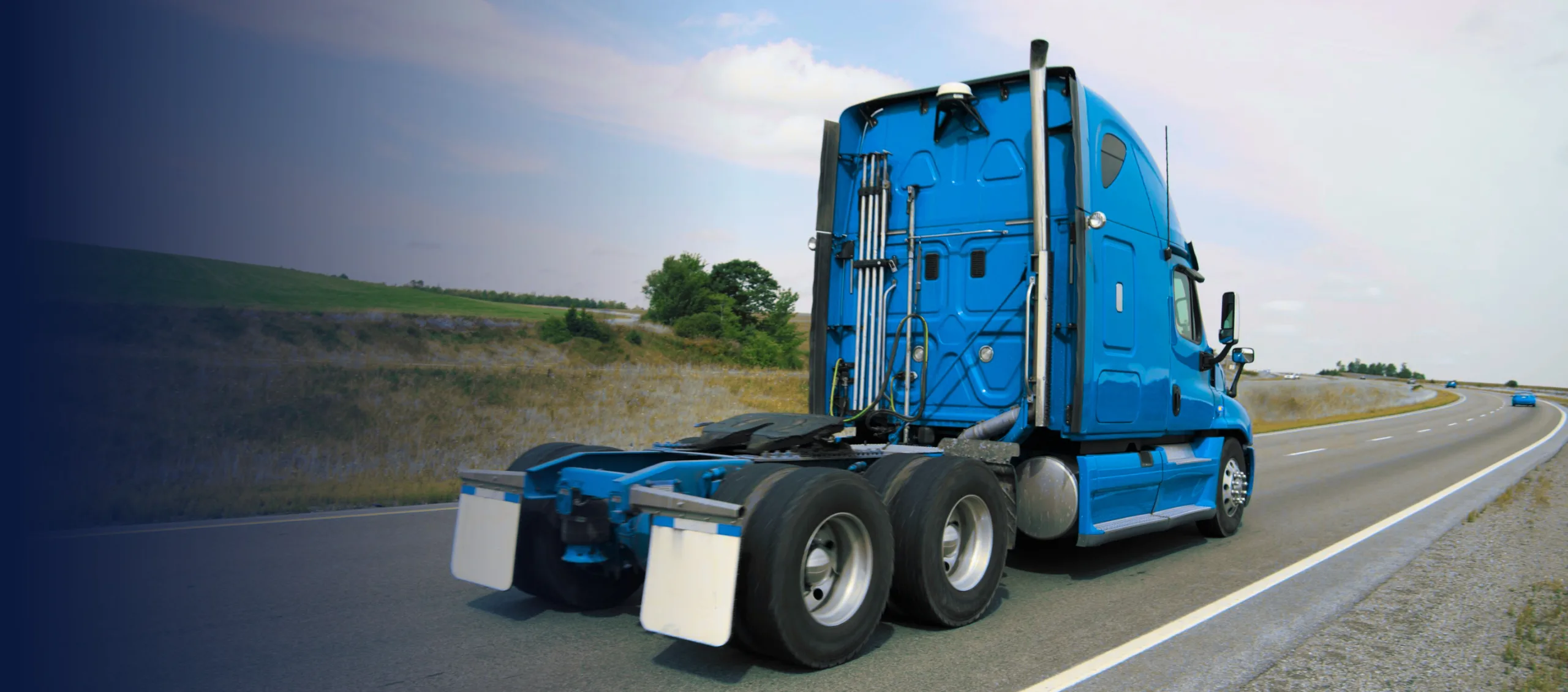 Blue power only semi-truck driving with no trailer attached, representing power only trucking services for carriers.